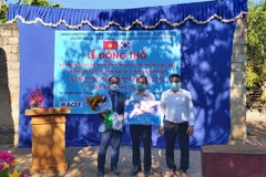 Ông Ko Jae Seung - Giám đốc phụ trách dự án xây dựng nhà tình thương của Trung tâm văn hóa Hàn Quốc (đứng bên trái) trao tặng vốn viện trợ không hoàn lại cho lãnh đạo huyện Bác Ái thực hiện dự án. (Ảnh: Công Thử/TTXVN)