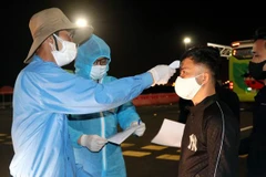 Tất cả các hành khách cùng lái xe, phụ xe đều phải thực hiện việc khai báo y tế, đo thân nhiệt trước khi ra, vào Quảng Ninh. (Ảnh: Văn Đức/TTXVN)