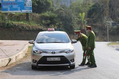 Lực lượng chức năng đang thực hiện kiểm tra, kiểm soát phương tiện taxi tại ngã ba Nà Nhạn (thành phố Điện Biên Phủ), không cho người dân ra vào địa bàn có trường hợp dương tính với Sars-Cov-2. (Ảnh: Xuân Tiến/TTXVN)