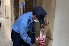 Bảo vệ chung cư tháo hàng rào barie và bảng thông báo cách ly. (Nguồn: laodong.vn)