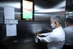 Dung dịch sát khuẩn luôn được để sẵn trong các thang máy tại các khu chung cư. (Ảnh: Phan Tuấn Anh/TTXVN)