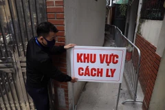 Lực lượng chức năng tiến hành phong tỏa nơi ở của bệnh nhân 2234. (Ảnh: Minh Đức/TTXVN)