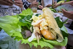 Du khách thưởng thức bánh xèo, món ngon Sài thành. (Ảnh: Mai Mai/Vietnam+)