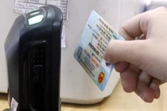 Dùng máy quét QR code trên Căn cước công dân gắn chíp để tra cứu thông tin người bệnh. (Ảnh: Đồng Thúy-TTXVN/)