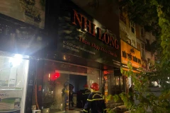 Lực lượng chức năng kịp thời có mặt dập tắt đám cháy tại đường Lạc Long Quân. (Ảnh Mạnh Khánh/Vietnam+)