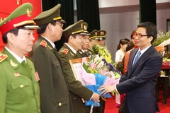 Phó Thủ tướng Chính phủ Vũ Đức Đam tặng hoa cho các chiến sĩ công an hoàn thành xuất sắc nhiệm vụ trong lĩnh vực khoa học công nghệ (Nguồn: TTXVN)