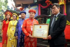 Đại diện Bộ Văn hóa, Thể thao, Du lịch trao bằng công nhận di sản văn hóa phi vật thể cấp quốc gia đối với Lễ hội Đền Hạ, Đền Thượng, Đền Ỷ La cho lãnh đạo thành phố Tuyên Quang. (Ảnh: Quang Cường/TTXVN)