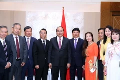 Thủ tướng Nguyễn Xuân Phúc, Chủ tịch Hội người Việt Nam tại Cộng hòa Séc Nguyễn Duy Nhiên (thứ tư từ trái sang), Chủ tịch Liên hiệp Hội người Việt Nam tại châu Âu Hoàng Đình Thắng (thứ ba từ trái sang) và các đại biểu chụp ảnh chung. (Ảnh: Thống Nhất/TTXV