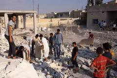Tìm kiếm các nạn nhân dưói những đống đổ nát sau vụ không kích tại tỉnh Idlib. (Nguồn: AFP/TTXVN)