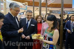 Các đại biểu dùng thử sản phẩm Tuần hàng Việt Nam tại Thái Lan. (Ảnh: PV/Vietnam+)