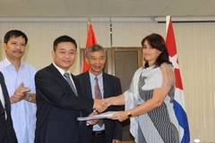 Tổng Giám đốc Văn phòng quản lý ZEDM Ana Teresa Igarza trao Giấy chứng nhận Đăng ký doanh nghiệp cho Giám đốc ViMariel Trần Anh Tuấn. (Ảnh: Lê Hà/TTXVN)