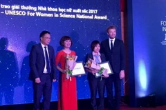 Hai nhà khoa học được Chủ tịch viện hàn lâm Khoa học Công nghệ Việt Nam Châu Văn Minh trao giải thưởng nhà khoa học nư xuất sắc 2017. (Ảnh: Hương Ly/Vietnam+)