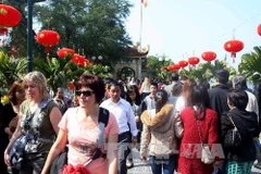 Du khách nước ngoài cùng người dân Hà Nội viếng chùa Trấn Quốc trong những ngày đầu năm Giáp Ngọ 2014. (Ảnh: Phạm Kiên/TTXVN)