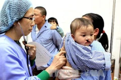 Kiểm tra sức khỏe trước khi tiến hành phẫu thuật cho trẻ bị hở môi, vòm miệng. (Ảnh: Dương Ngọc/TTXVN)