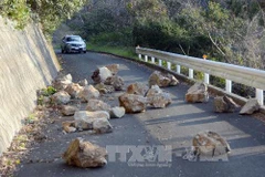 Đất đá rơi xuống lòng đường sau trận động đất tại Seiyo sáng 14/3. (Nguồn: Kyodo/TTXVN)