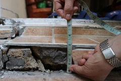 Một nền nhà của người dân đường Nguyễn Văn Trỗi bị trồi sụt, nứt gãy. (Ảnh: Nguyễn Dũng/TTXVN)