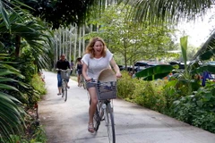 Du khách nước ngoài đi dạo bằng xe đạp tại homestay Út Hiên, quận Cái Răng. (Ảnh: Thanh Liêm/TTXVN)