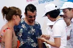 Du khách nước ngoài hào hứng đổi sim để trải nghiệm dịch vụ. (Ảnh: T.H/Vietnam+)