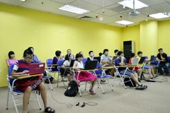 Những em nhỏ mê lập trình nhờ sự kèm cặp bởi những thầy cô giáo "không chuyên" của FPT. (Ảnh: H.T/Vietnam+)