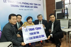 Thứ trưởng Bộ Thông tin và Truyền thông Nguyễn Minh Hồng (thứ hai từ phải sang) trong buổi lễ trao tặng máy tính cho Trung tâm Nghị lực sống của Huawei. (Ảnh: T.H/Vietnam+)