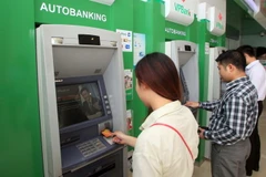 Khách hàng giao dịch tại một điểm ATM tại Hà Nội. (Ảnh :Trần Việt/TTXVN)