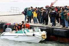 Thân nhân các nạn nhân trong vụ chìm phà Sewol theo dõi quá trình trục vớt ở ngoài khơi đảo Jindo, Hàn Quốc ngày 28/3. (Nguồn: EPA/TTXVN)