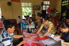 Người dân thôn Vịnh Mốc, xã Vĩnh Thạch, huyện Vinh Linh, tỉnh Quảng Trị làm thủ tục nhận tiền đền bù sự cố môi trường biển. (Ảnh Trần Tĩnh/TTXVN)