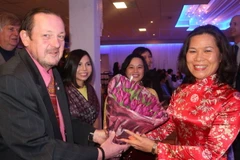 Đại sứ Việt Nam tại Hà Lan Ngô Thị Hòa tặng hoa đại biểu dự buổi gặp mặt. (Ảnh: TTXVN)