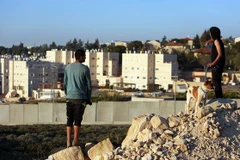 Hai người dân Palestine nhìn về phía khu định cư Do Thái Beit El ở khu Bờ Tây. (Nguồn: AFP​)