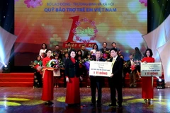 Phó Chủ tịch nước Đặng Thị Ngọc Thịnh tiếp nhận tượng trưng số tiền ủng hộ của các nhà tài trợ cho Quỹ Bảo trợ Trẻ em Việt Nam. (Ảnh: Quang Quyết/TTXVN)