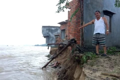 Một ngôi nhà chênh vênh sắp bị lũ 'nuốt chửng'. (Ảnh: Phước Ngọc/TTXVN)