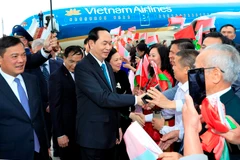 Cán bộ, nhân viên Đại sứ quán Việt Nam và đại diện cộng đồng người Việt Nam tại Cộng hoà Belarus đón Chủ tịch nước Trần Đại Quang và Phu nhân tại sân bay Quốc tế Minsk. (Ảnh: Nhan Sáng/TTXVN)