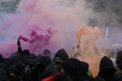 Người biểu tình trùm đầu dùng bom khói tại Kreuzberg, Đức. (Nguồn: AFP)