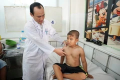 Bác sỹ thăm khám cho bệnh nhi lõm ngực trước khi phẫu thuật. (Ảnh: Phương Vy/TTXVN)