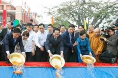 Chủ tịch nước Trần Đại Quang và Phu nhân cùng Bí thư Thành ủy TP. Hồ Chí Minh Đinh La Thăng và đông đảo bà con kiều bào thực hiện nghi lễ thả cá chép tại Bến cảng Nhà Rồng. (Ảnh: Nhan Sáng/TTXVN)