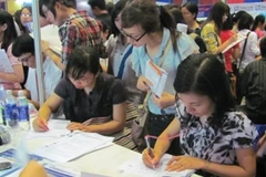 Ứng viên làm hồ sơ tuyển dụng tại Siêu thị việc làm 2011. (Ảnh: Phạm Mai/Vietnam+)