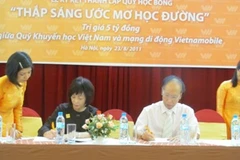 Các bên cùng ký kết thành lập Quỹ học bổng. (Ảnh: Phạm Mai/Vietnam+)