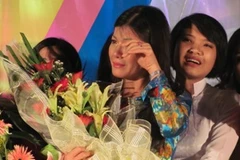 Cô Hiệu trưởng Nguyễn Thị Nhiếp nghẹn ngào trong vòng tay học trò. (Ảnh: Phạm Mai/Vietnam+)