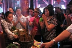 Thí sinh, phụ huynh thành tâm khấn vái. (Ảnh: Hồng Kiều/Vietnam+)