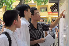 Thí sinh điểm thi Trường Trung học phổ thông Việt Đức dò tìm số báo danh. (Ảnh: Phạm Mai/Vietnam+).