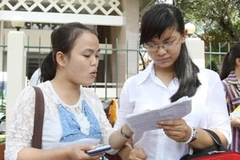 Thí sinh trao đổi bài sau buổi thi. (Ảnh: TTXVN)