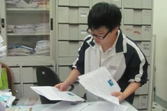 Học sinh phân loại hồ sơ dự thi đại học tại trường Trung học phổ thông Trần Phú, Hà Nội. (Ảnh: Phạm Mai/Vietnam+)