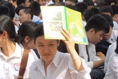 Thí sinh điểm thi Trường Trung học phổ thông Việt Đức ngồi nghe quy chế dưới trời nắng gay gắt. (Ảnh: Phạm Mai/Vietnam+).