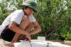Học sinh rốn lũ miền Trung đang cố "cứu" sách giáo khoa bị ướt. (Ảnh: Mạnh Hùng/Vietnam+).