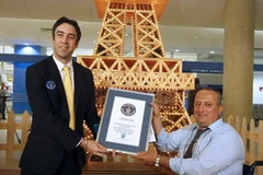 Nhân viên Tổ chức công nhận những Kỷ lục Thế giới Guines trao chứng nhận Mô hình Tháp Eiffel bằng diêm cao nhất thế giới cho anh Tufiq Daher. (Ảnh: AFP/TTXVN) 
