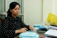 Bí thư chi đoàn phường Hàng Đào Nguyễn Quỳnh Anh phân chia các lá phiếu bầu cử. (Ảnh: Thùy Giang/Vietnam+)