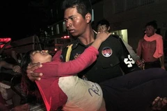 Lực lượng chức năng đưa nạn nhân bị thương đi cấp cứu. (Nguồn: Reuters)