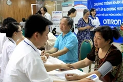 Các bác sỹ Bệnh viện Bạch Mai khám, tư vấn miễn phí về huyết áp cho người dân. (Ảnh: Dương Ngọc/TTXVN)