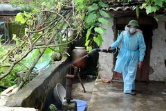 Cán bộ y tế dự phòng phun thuốc phòng dịch tại các gia đình. (Ảnh: Thanh Hà/TTXVN) 