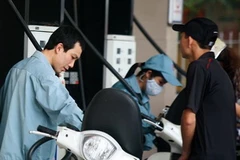 Người dân mua xăng tại cây xăng trên đường Yên Phụ, thành phố Hà Nội. (Ảnh: Phạm Hậu/TTXVN) 